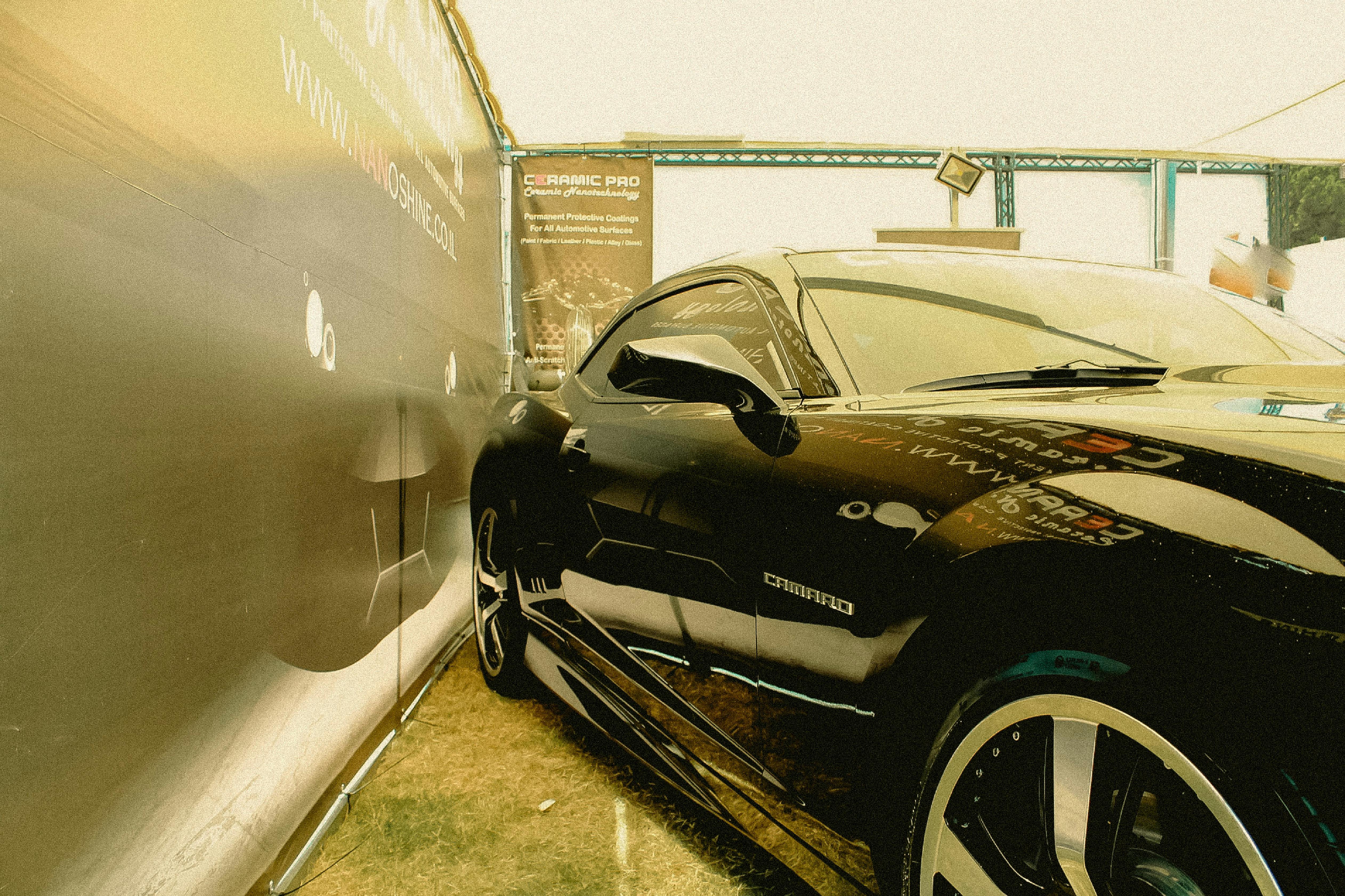 מכונית ספורט שחורה חונה לצד שלט | Black Sports Car Parked Next to a Sign