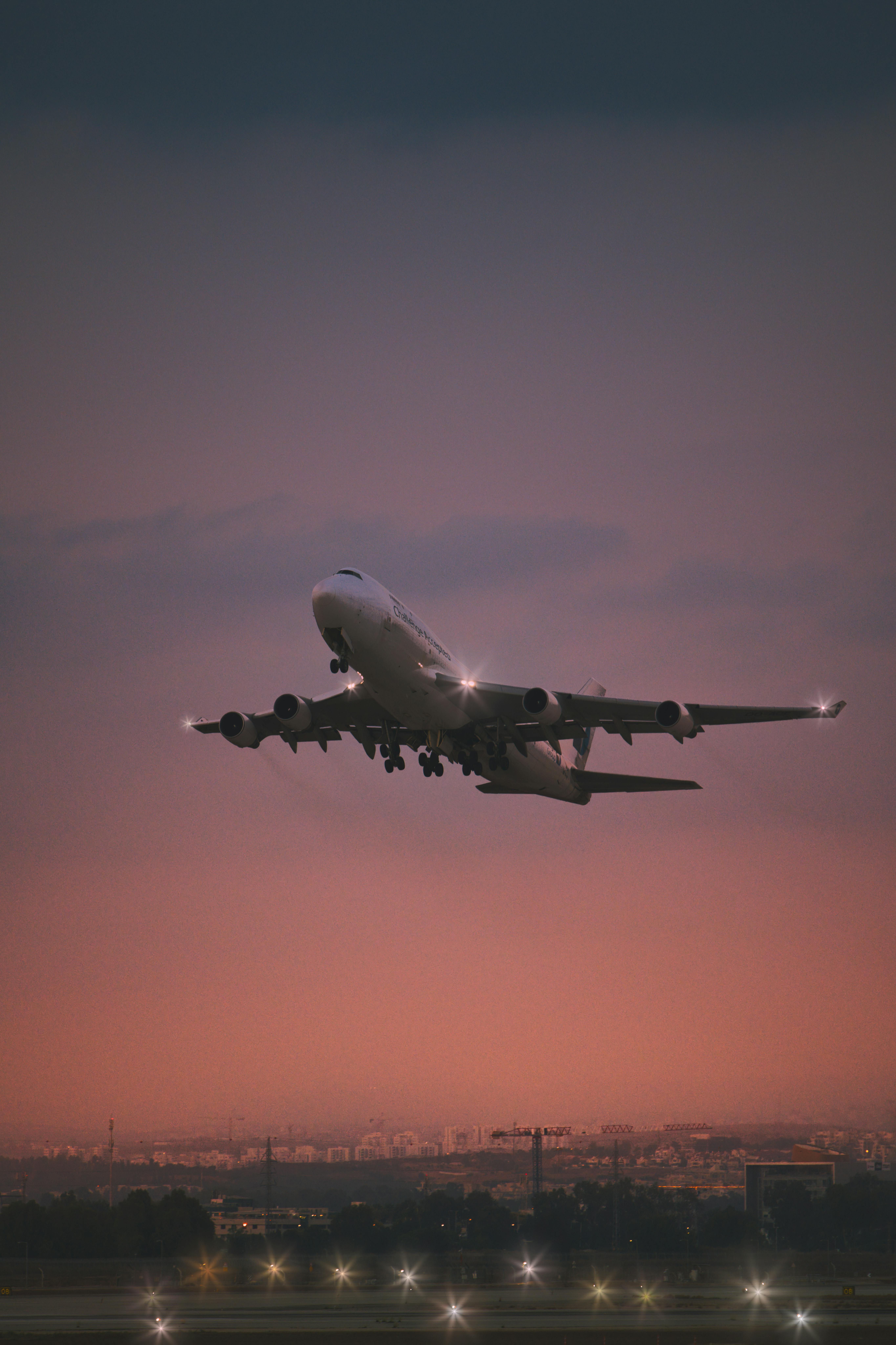 מטוס נוסעים ממריא מעל עיר בשעת דמדומים | Passenger Airplane Taking Off Over City at Dusk