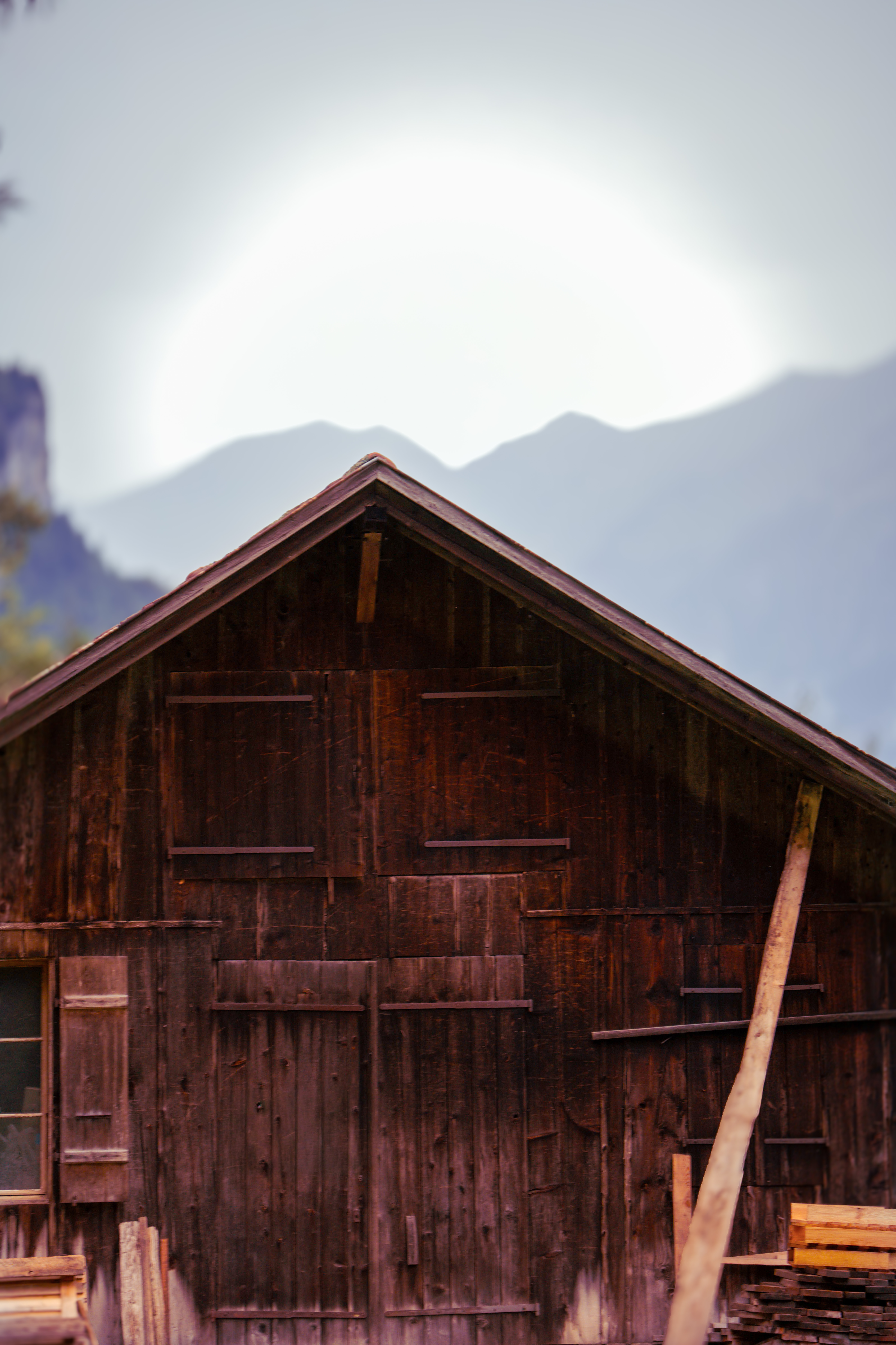 חזית של בקתת עץ כפרית ישנה על רקע הרים מעורפלים